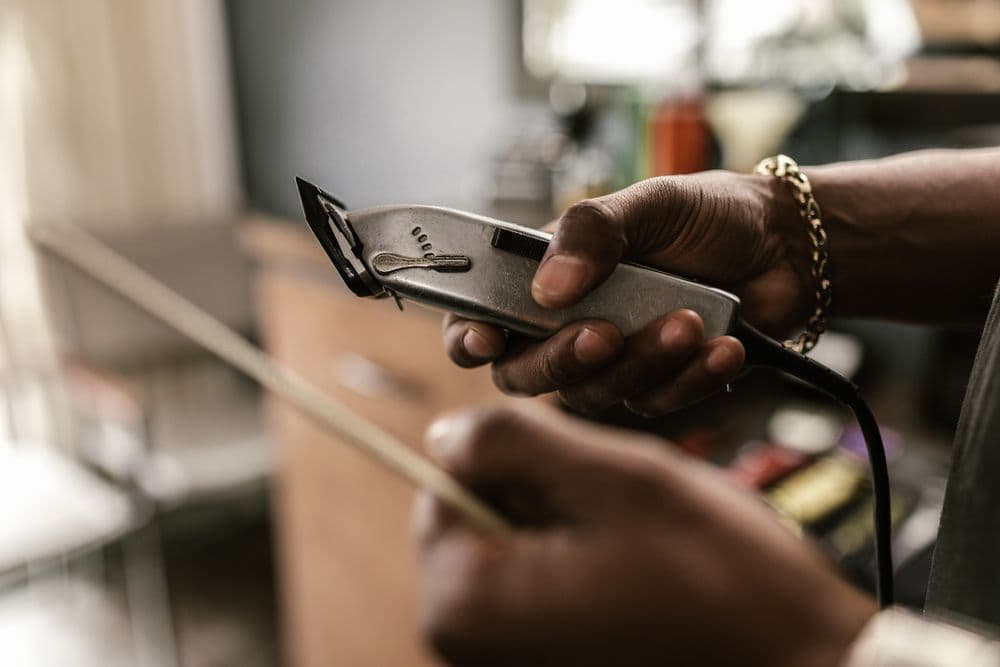 Barber holding clippers and a comb
