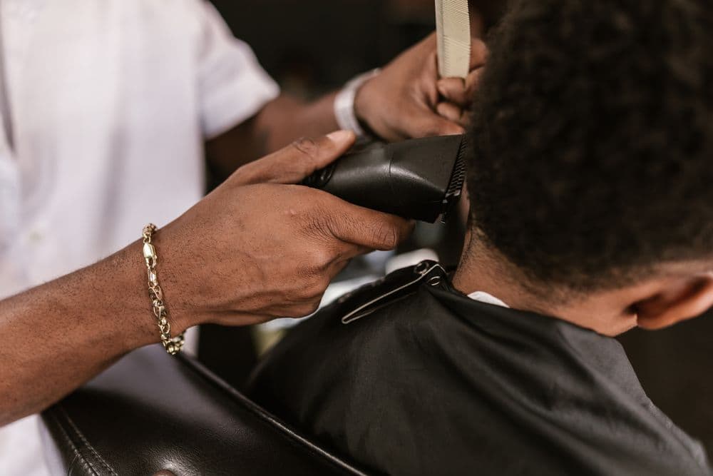 Barber cleaning up a client's neckline with clippers